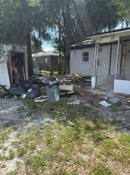 Backyard debris pile next to the house before cleanout