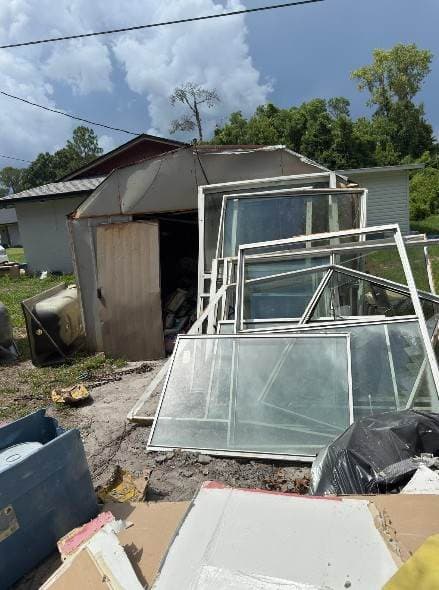Second shed full of glass panels and construction debris before cleanout